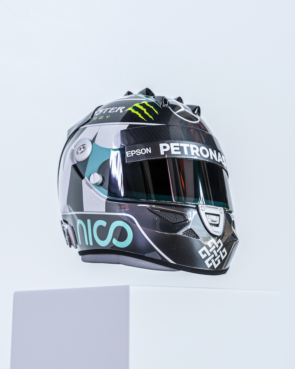 A racing helmet displayed on a white platform.