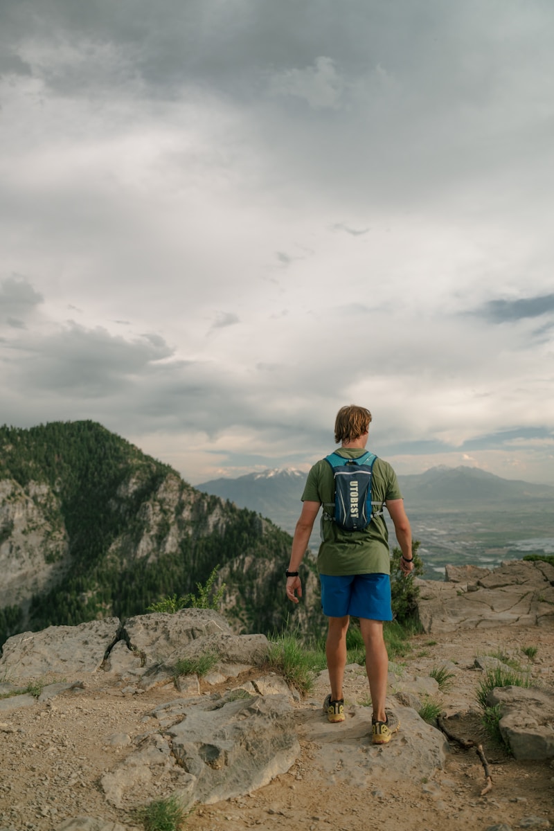 A hiker stands atop a mountain, enjoying the view.