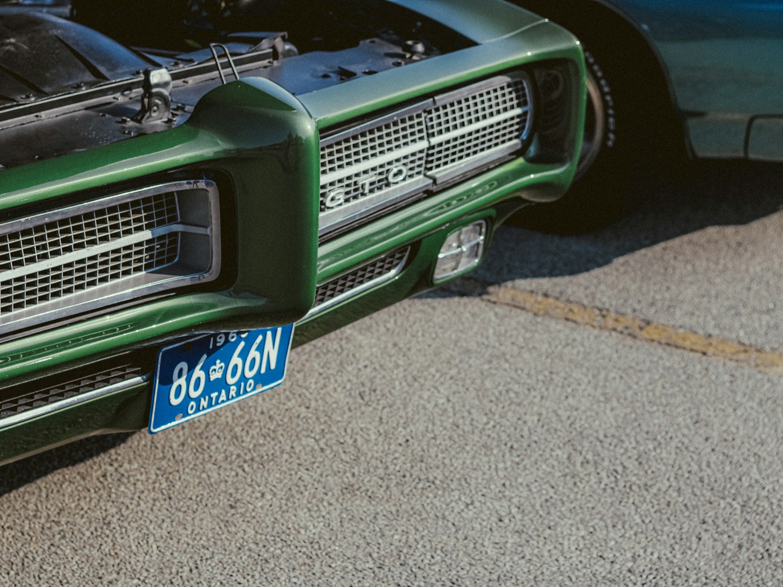 A green classic car is displayed.